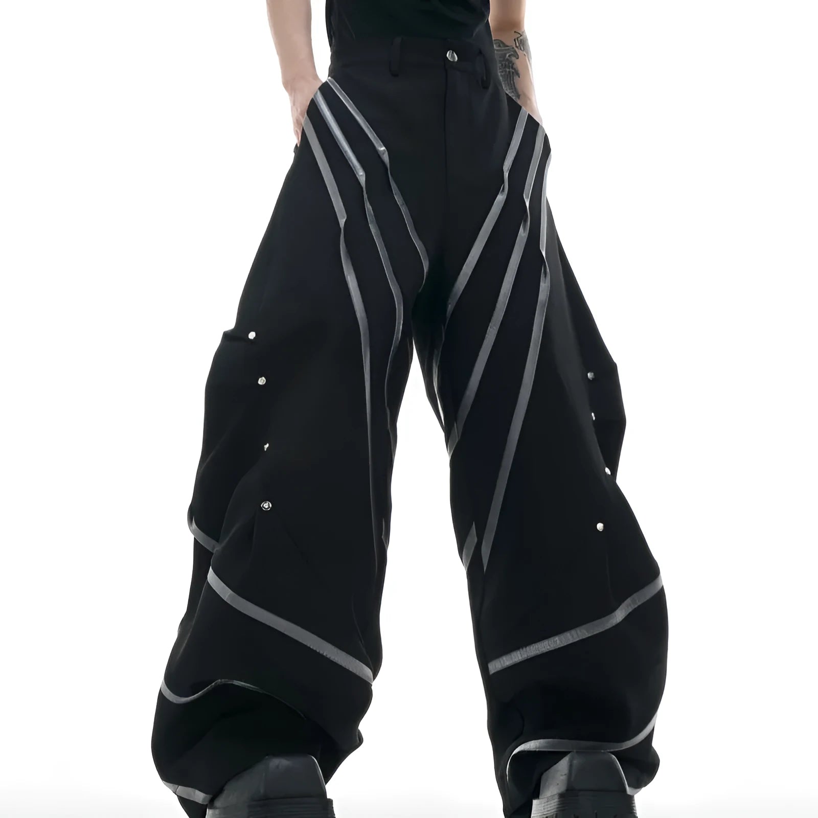 Men's black trousers with three-dimensional cutting and metal rivet pleats on a white background.