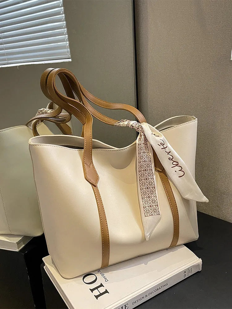 Soft women's crossbody tote bag in bucket silhouette showing sandwich pocket detail and shoulder strap