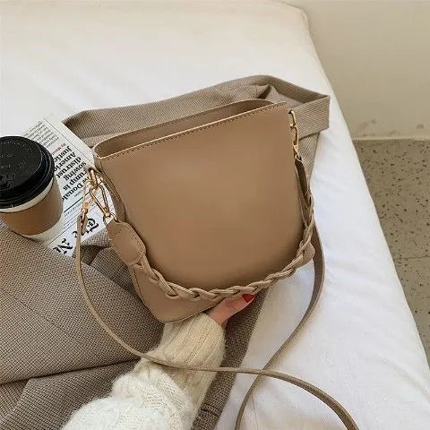 Retro woven PU bucket bag in khaki colour with crossbody strap shown in model shot