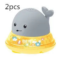 Electric whale bath toy with automatic water spray and flashing lights on a base