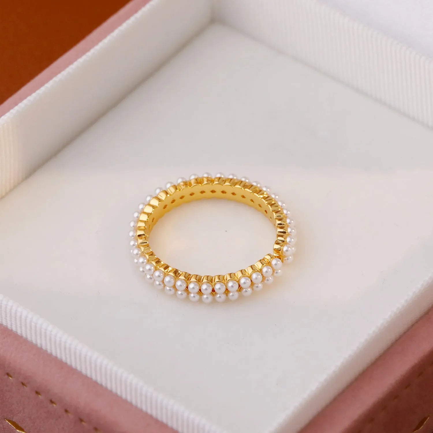 Gold geometric open ring for women with round pearls on a white background.