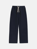 Man wearing loose fit grey fleece-lined sweatpants with an elastic drawstring waist.