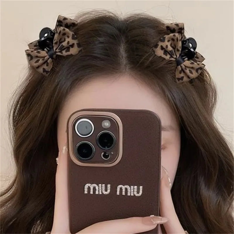 Pair of leopard bow plastic hair barrettes with Seiko finish in brown leopard pattern