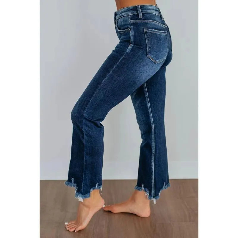 Women's solid colour denim jeans with hand-worn distressing in dark blue on a model
