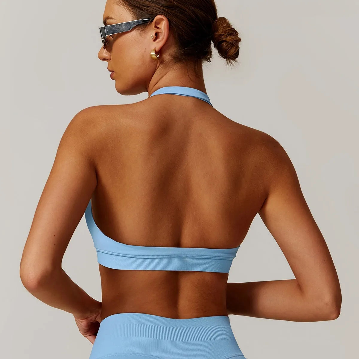 Women's black halter yoga bra with removable pads shown on a mannequin