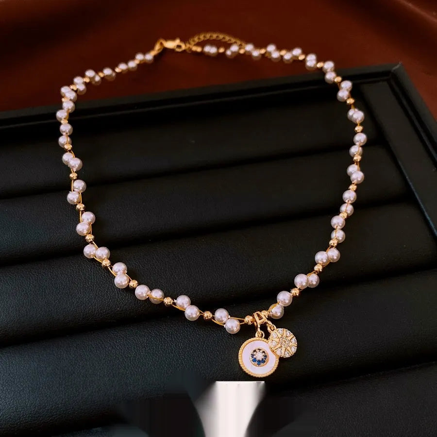 Gold electroplated necklace with zircon and imitation pearl pendant on an adjustable clavicle chain.