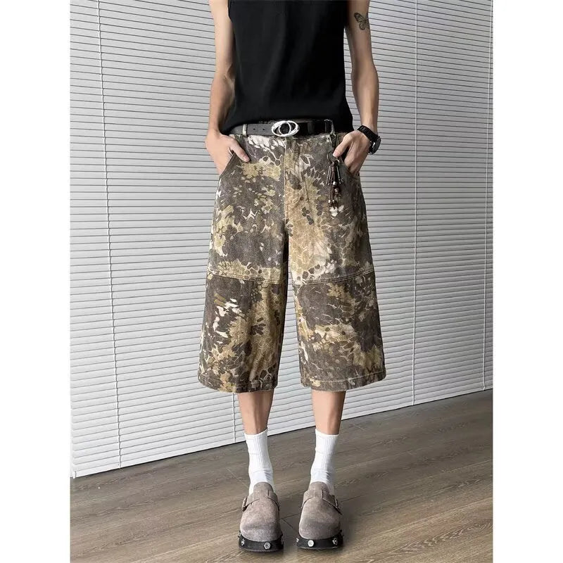 Yellow snake camouflage pattern on cropped denim jeans laid flat.