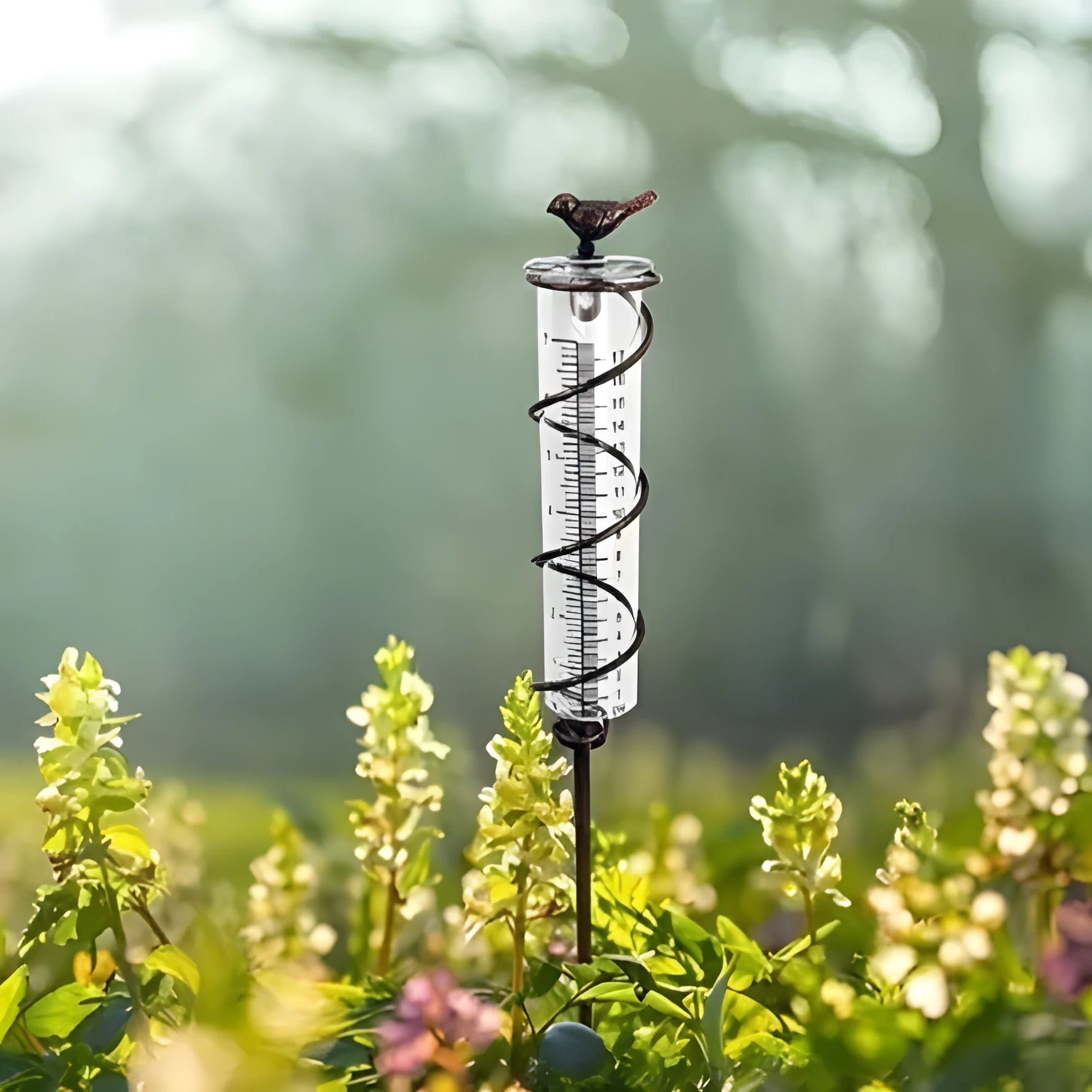 Cast iron garden rain gauge with hummingbird ornament and measurement scale.