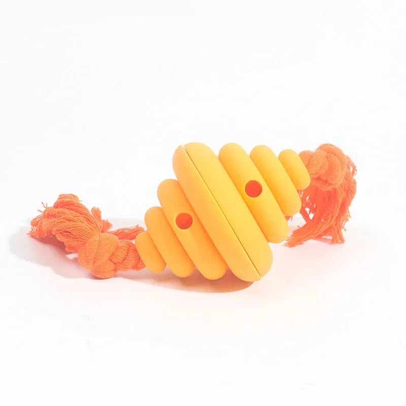 Green and yellow silicone dog ball with attached rope for tug-of-war and treat dispensing.