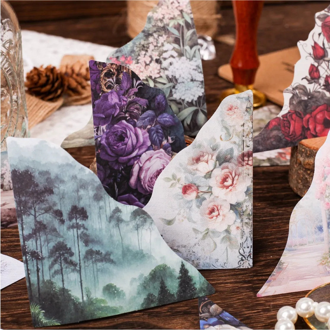 Decorative notebook set showing artistic covers in spring vine, pink plum, red rose, blue, green field, and purple dew colours.