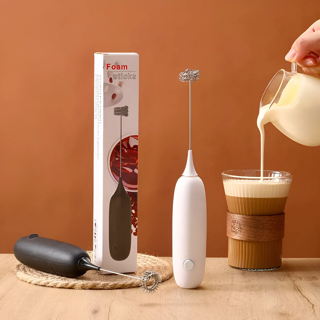Black and white handheld electric milk frother with whisk attachment for coffee and beverage preparation