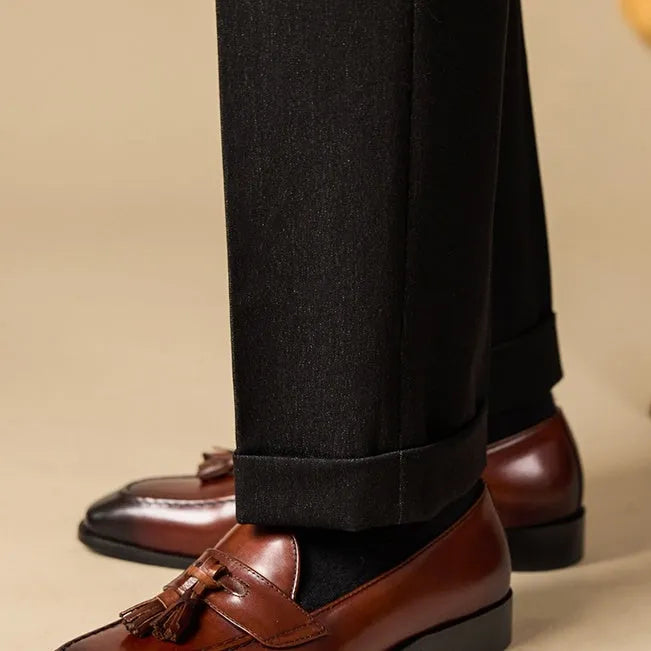 Men's black leather tassel loafers with polished finish and rubber soles for business casual wear