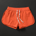 Men's loose orange, fluorescent green, or black polyester beach shorts on a size chart