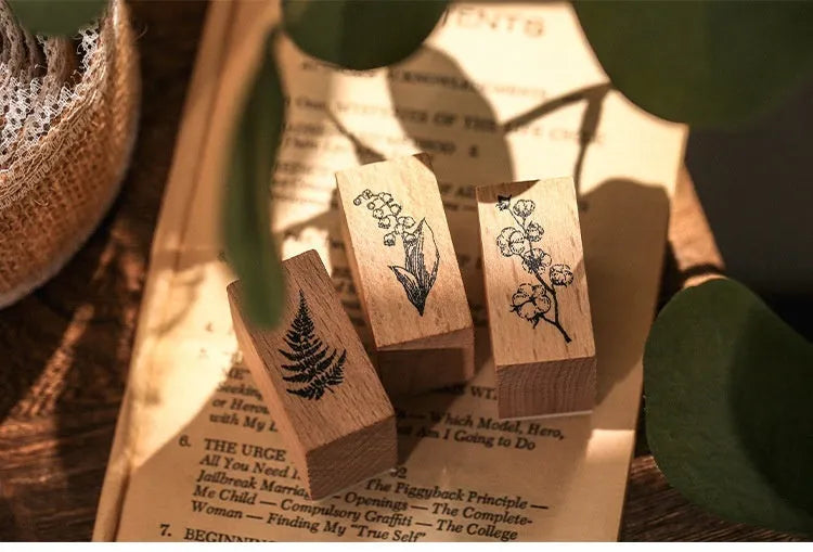 Wooden decorative stamp set with seven hand-carved botanical or celestial designs for paper crafts