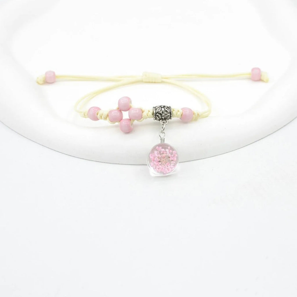 Women's glass bracelet with large beads containing real dried flowers, shown in blue colour.
