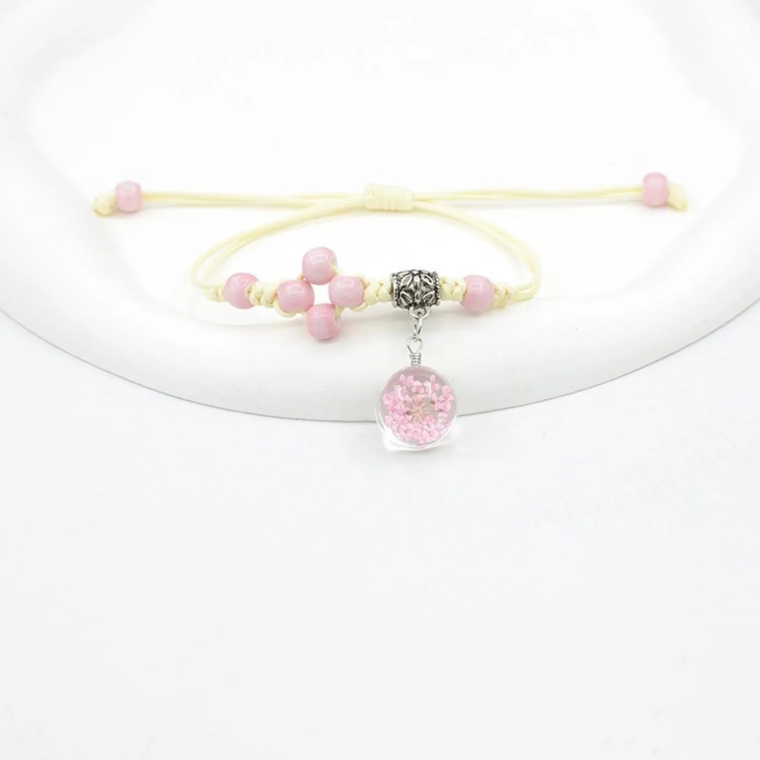 Women's glass bracelet with large beads containing real dried flowers, shown in blue colour.