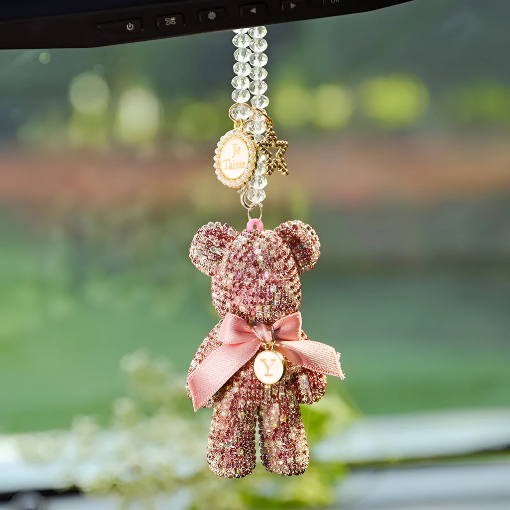 Close-up of a crystal rhinestone Violent Bear ornament on a car rearview mirror.