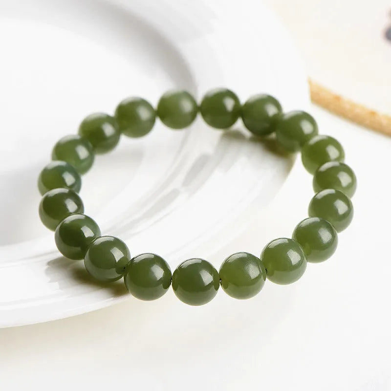 Polished Hetian jade ball bracelet on wrist, showing clear beads.