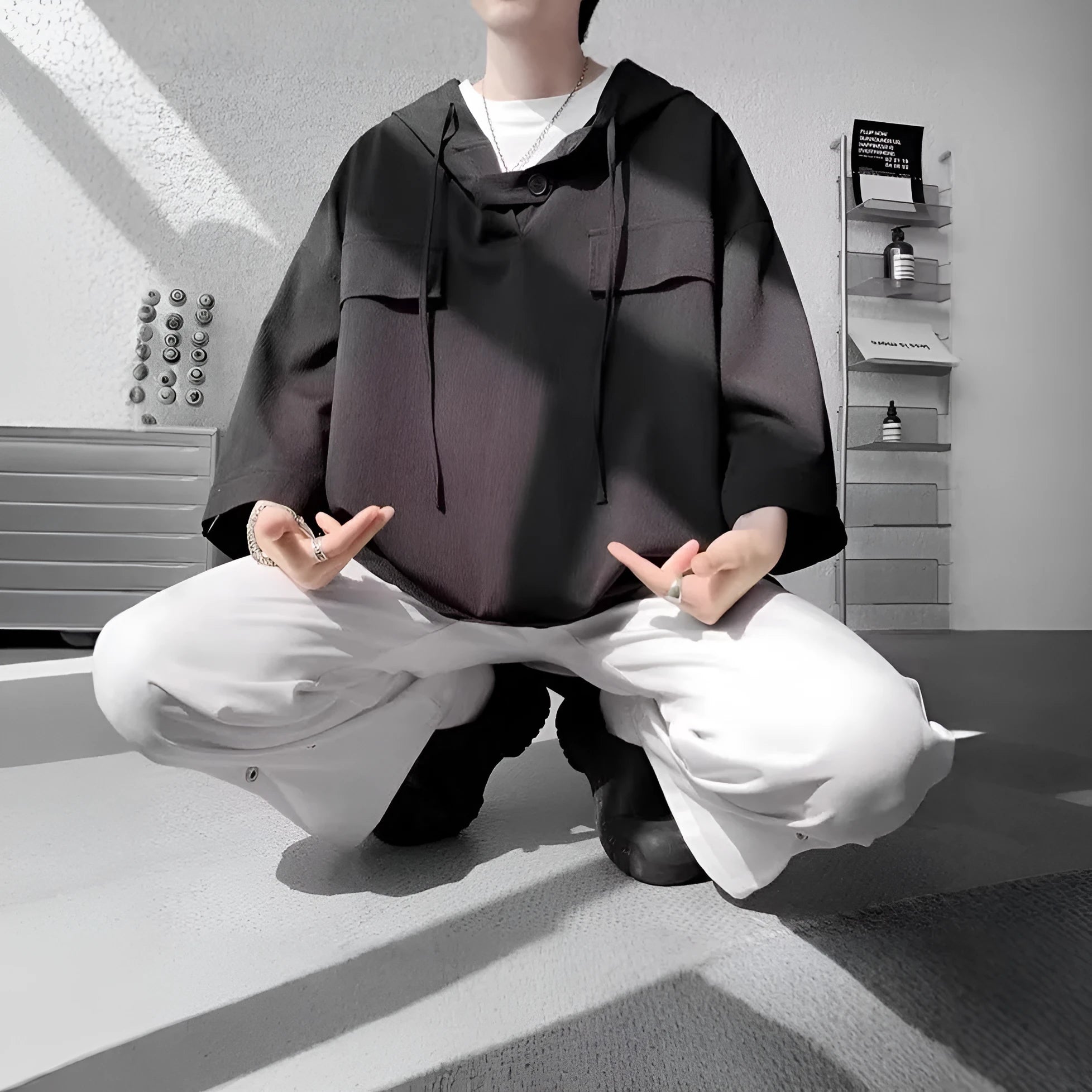 Man wearing a loose-fit black polyester hooded t-shirt with short sleeves.