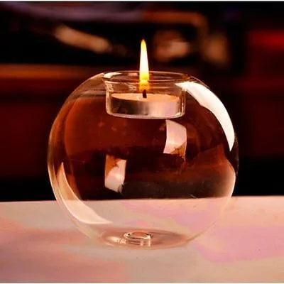 Handmade clear hollow glass sphere candle holder with tea light inside on wooden table