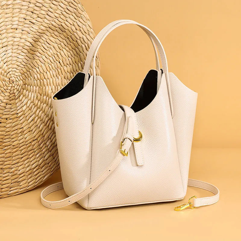 Genuine leather women's hand holding bucket bag in retro style with file compartment interior.