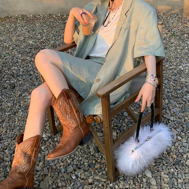 Brown women's embroidered Martin boots with a mid-calf height and low square heel.