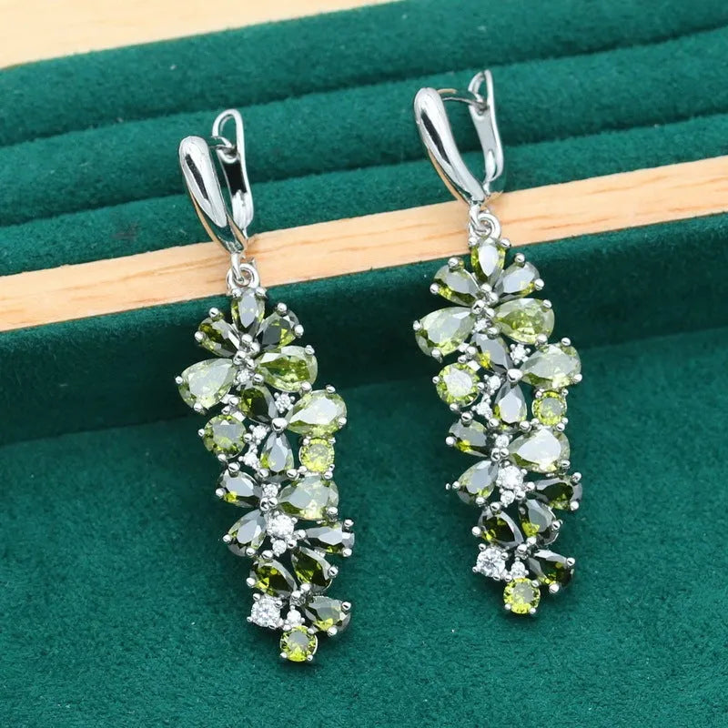Retro-style jewellery set with necklace, bracelet, earrings, and ring featuring floral patterns in olive and purple colours.
