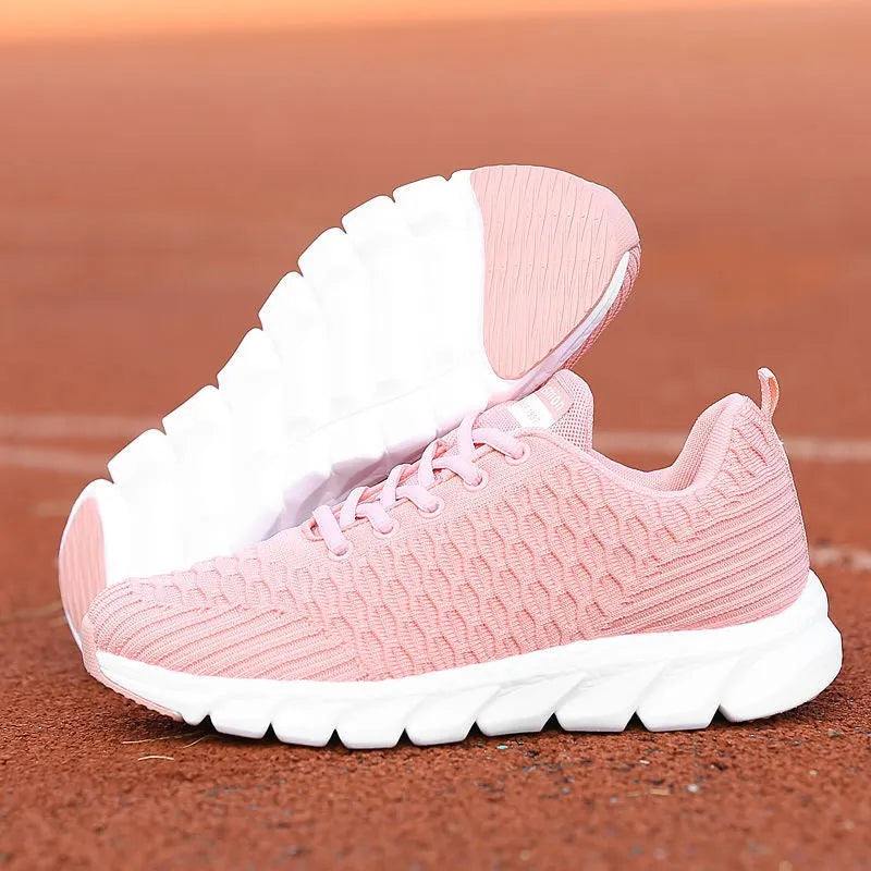 Women's running shoes in black, pink and white colours showing flyweave upper texture