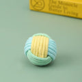 Handmade blue powder and green plush cotton ball cat toy for teeth grinding and play.