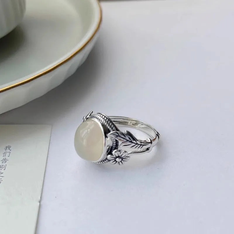 Adjustable copper vintage ring with imitation white chalcedony stone on a U-shaped band.