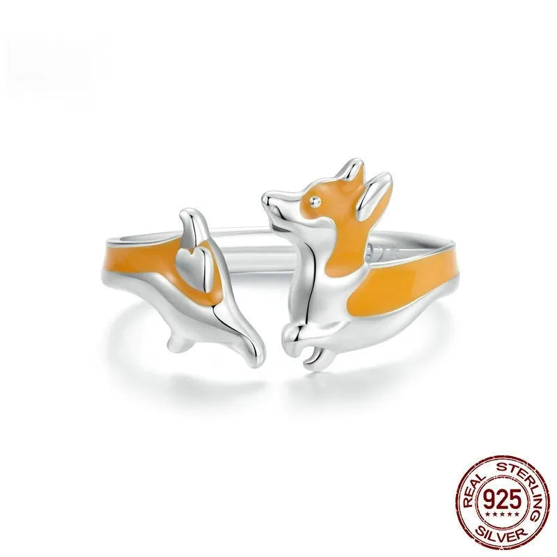 Silver-coloured cartoon corgi dog ring for women on a plain background.