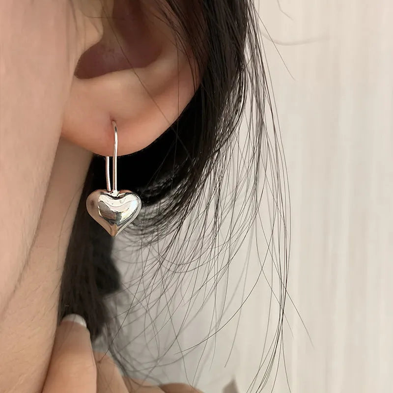 Korean style heart-shaped earrings with glossy finish and silver colour