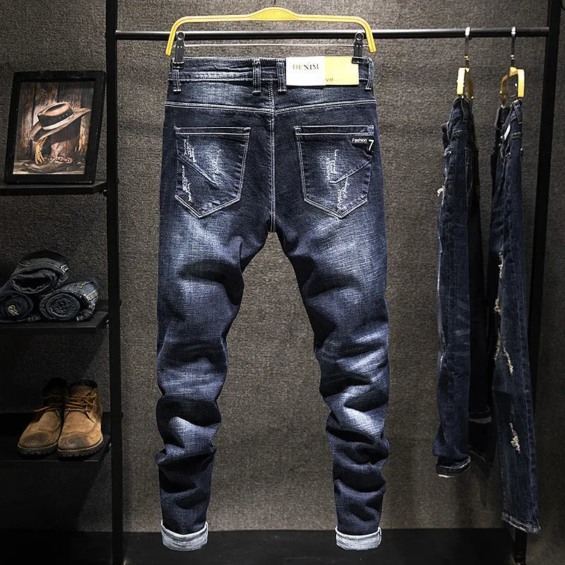 Men's dark blue skinny jeans with a slim fit and mid waist, laid flat.