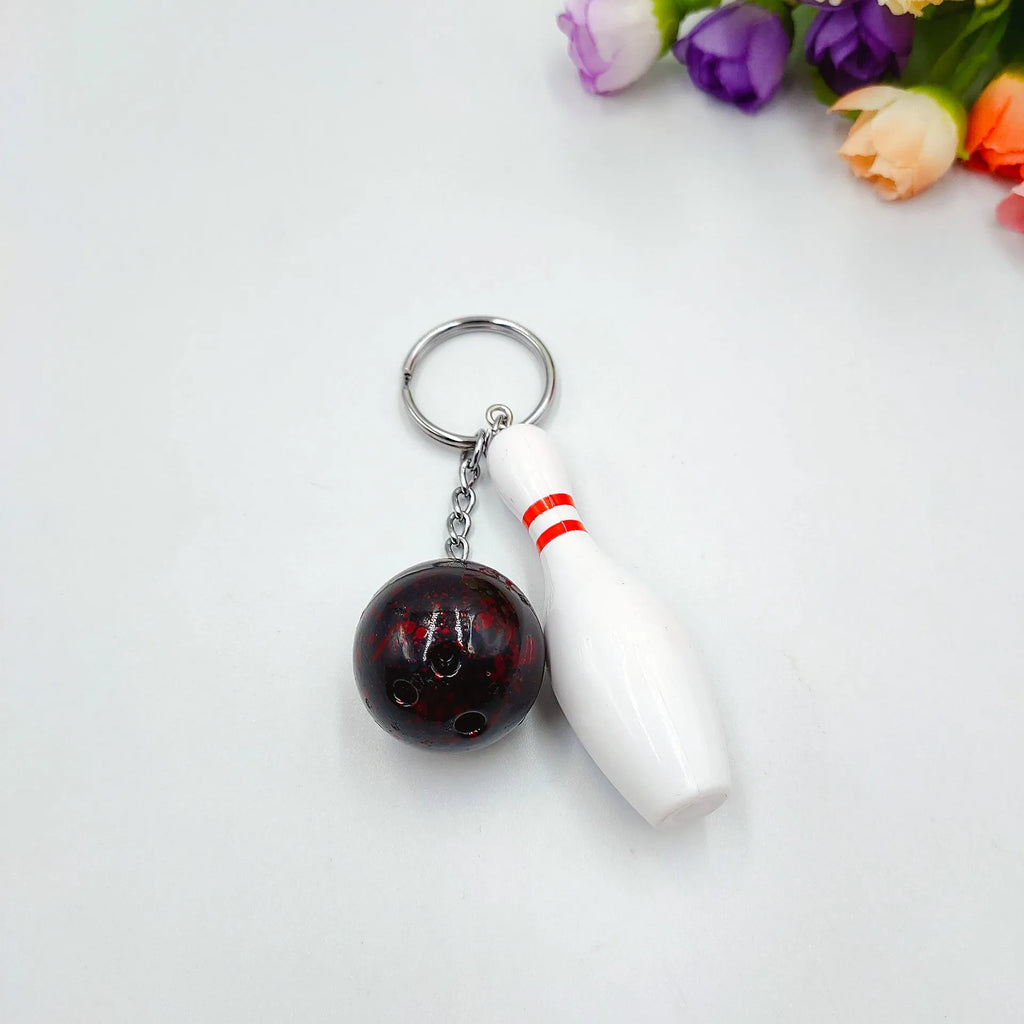 Mini bowling ball simulation keychain in blue, red, purple, and green colours.