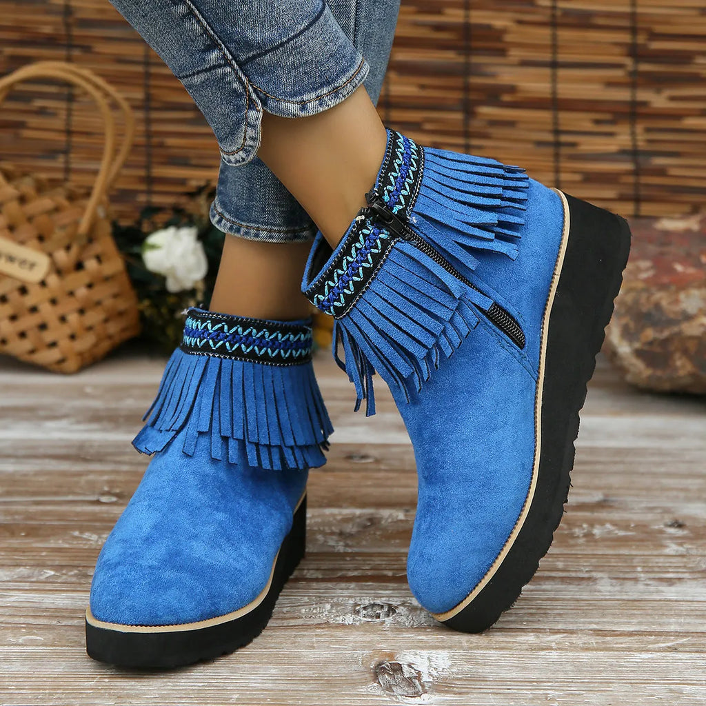 Women's suede ankle boot with wedge rubber sole, side zip, and tassel detail in dark brown.
