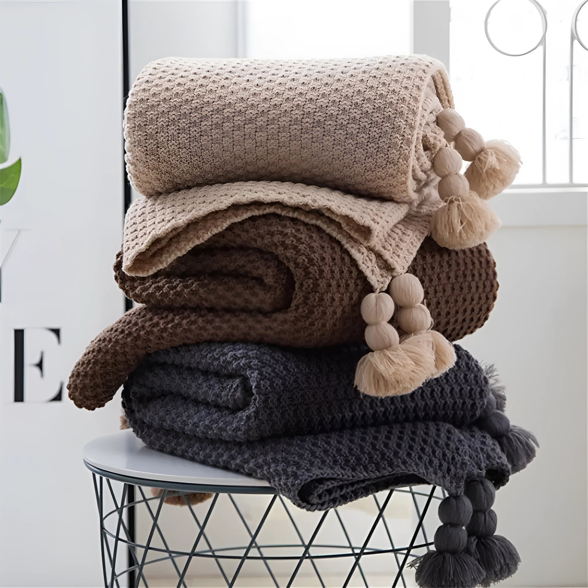 Nordic style fringed knit ball acrylic blanket in neutral colour on sofa