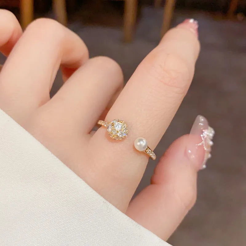 Golden round zircon open-end pearl ring with geometric shape on female hand