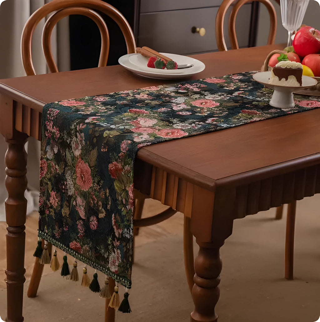 Long European-style retro table runner with decorative tassels in a floral design on a wooden table.
