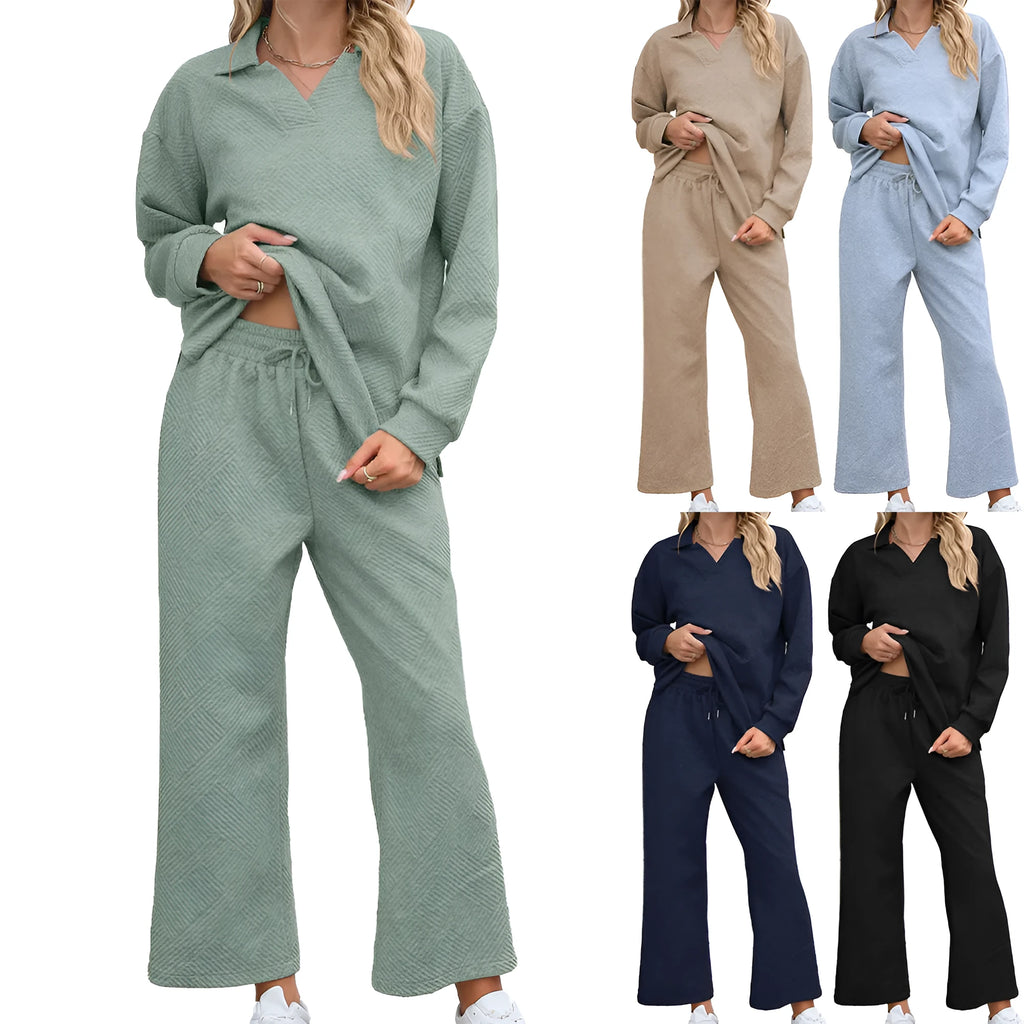 Women's black knitted jacquard two-piece suit with long sleeve top and elastic waist cropped trousers on a hanger.