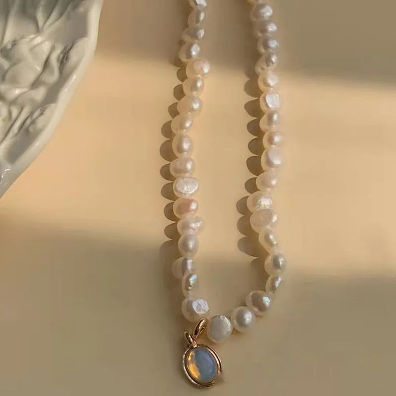 Adjustable vintage pearl necklace with geometric design on a grey background.
