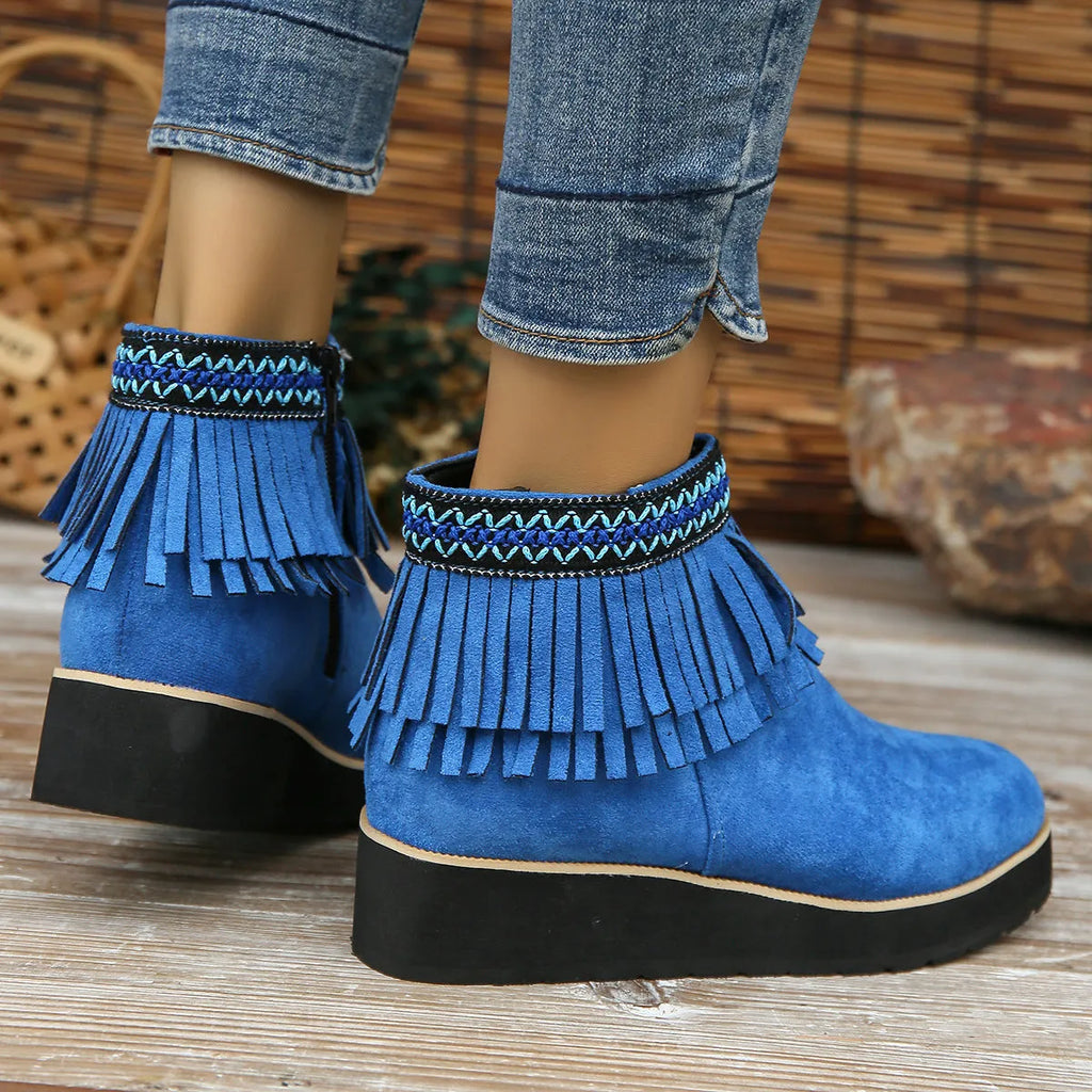 Women's suede ankle boot with wedge rubber sole, side zip, and tassel detail in dark brown.