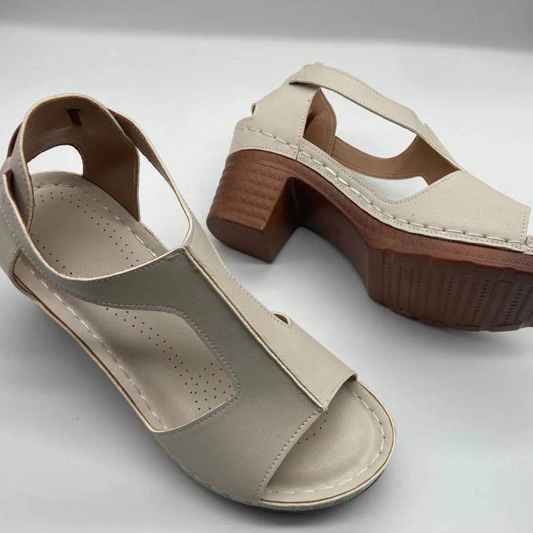 Women's white peep toe wedge sandals with Roman-style buckle ankle straps on a low heel.