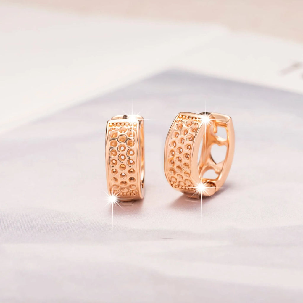 Rose gold electroplated women's earrings with three hollowed heart shapes in circular arrangement