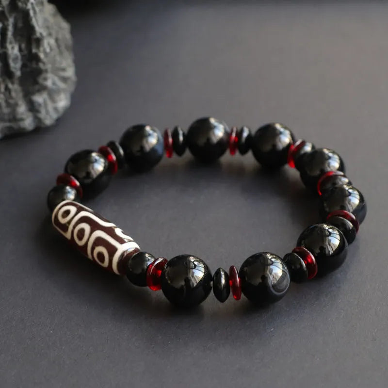 Black agate dzi bead bracelet with geometric beads and hand-woven construction