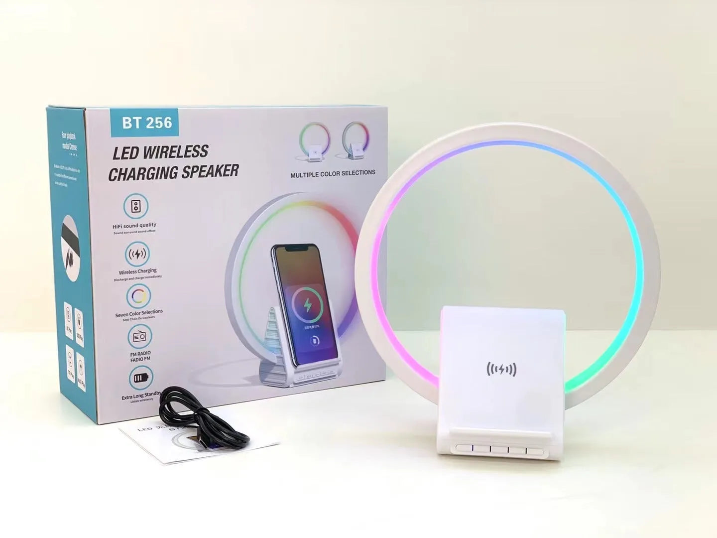 White smart Bluetooth speaker with 15W wireless charging surface and USB port on desktop