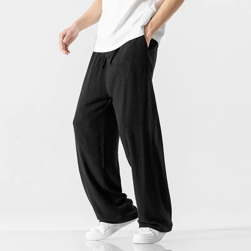 Men's beige bamboo fibre straight-leg cropped trousers with a drawstring waist on a neutral background.