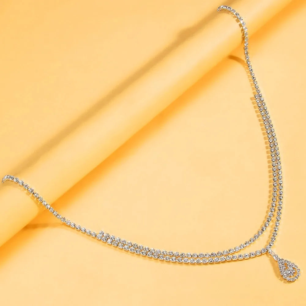 Gold waist chain with water drop pendant and rhinestone details, showing lobster clasp closure
