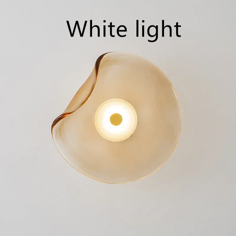 Round decorative wall lamp with glass shade in choice of cognac, light purple, or smoky grey finishes for bedroom lighting