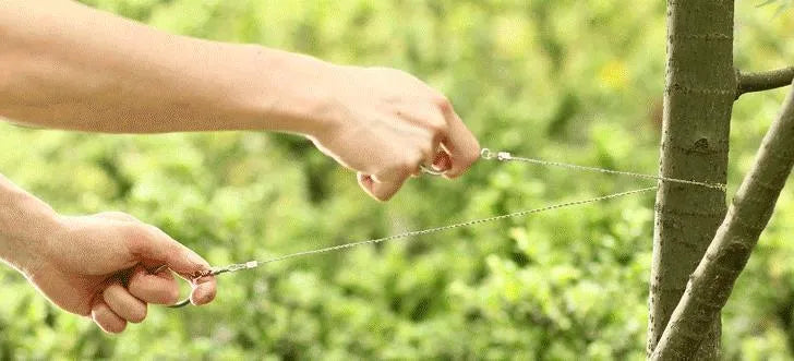 Close-up of a black coiled stainless steel wire survival saw with a total length of 70cm.