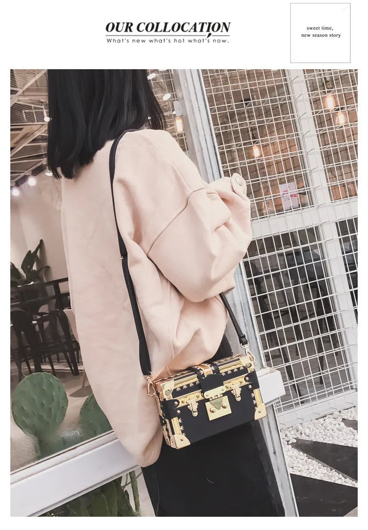 Women's black hard case shoulder bag with flap closure and single strap